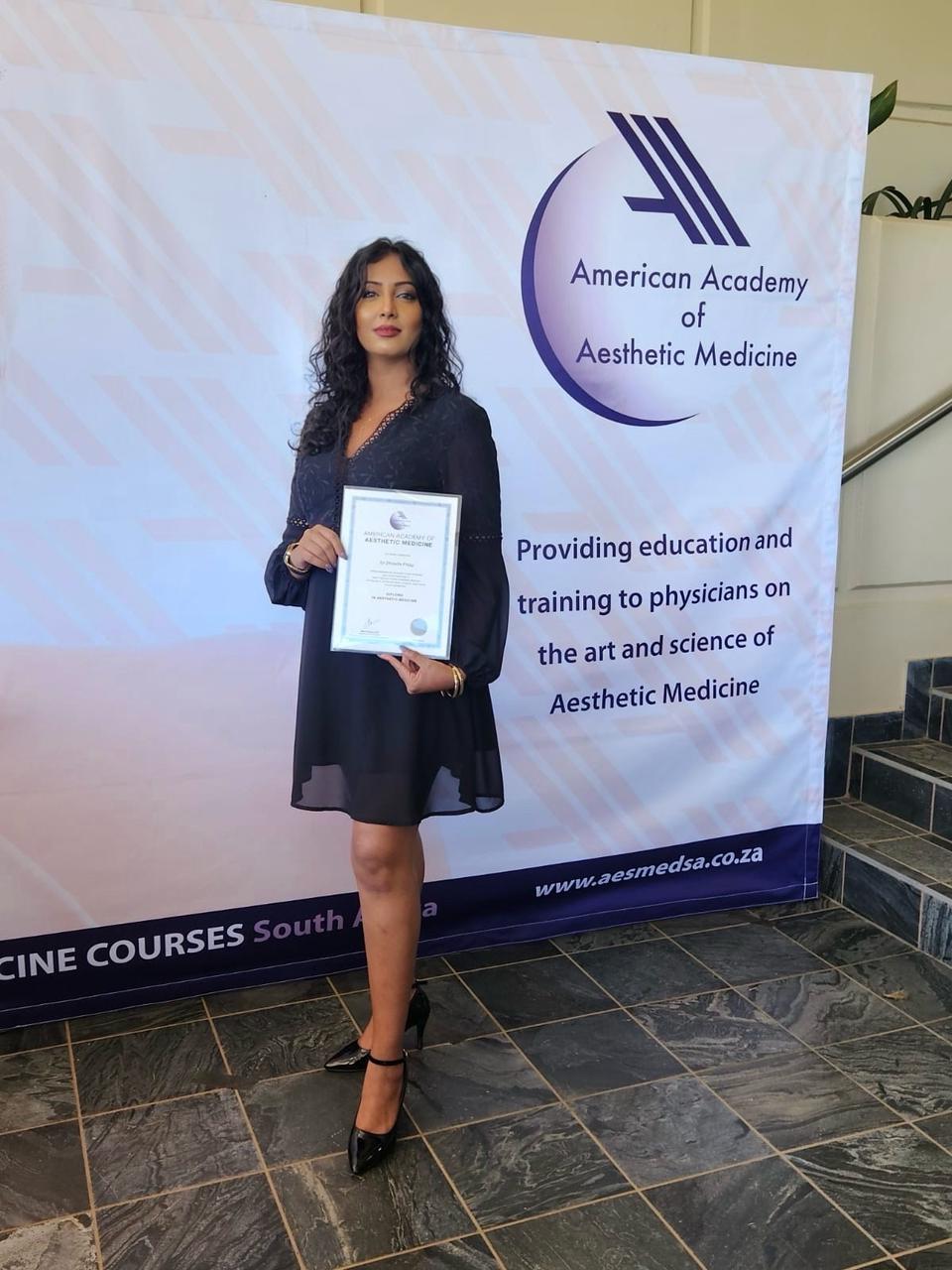Dr Zhinelle Pillay holding an aesthetic medicine training certificate